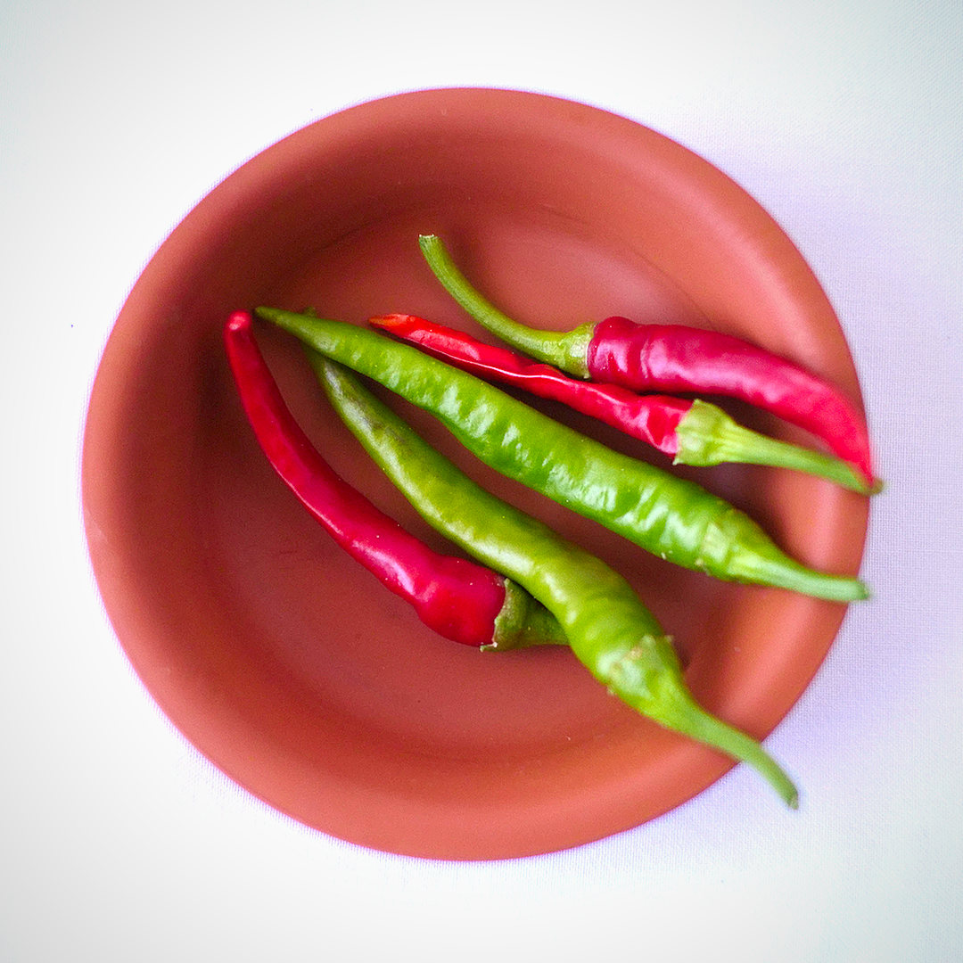 World of Chillies red and green Cayenne chillies in terracotta dish